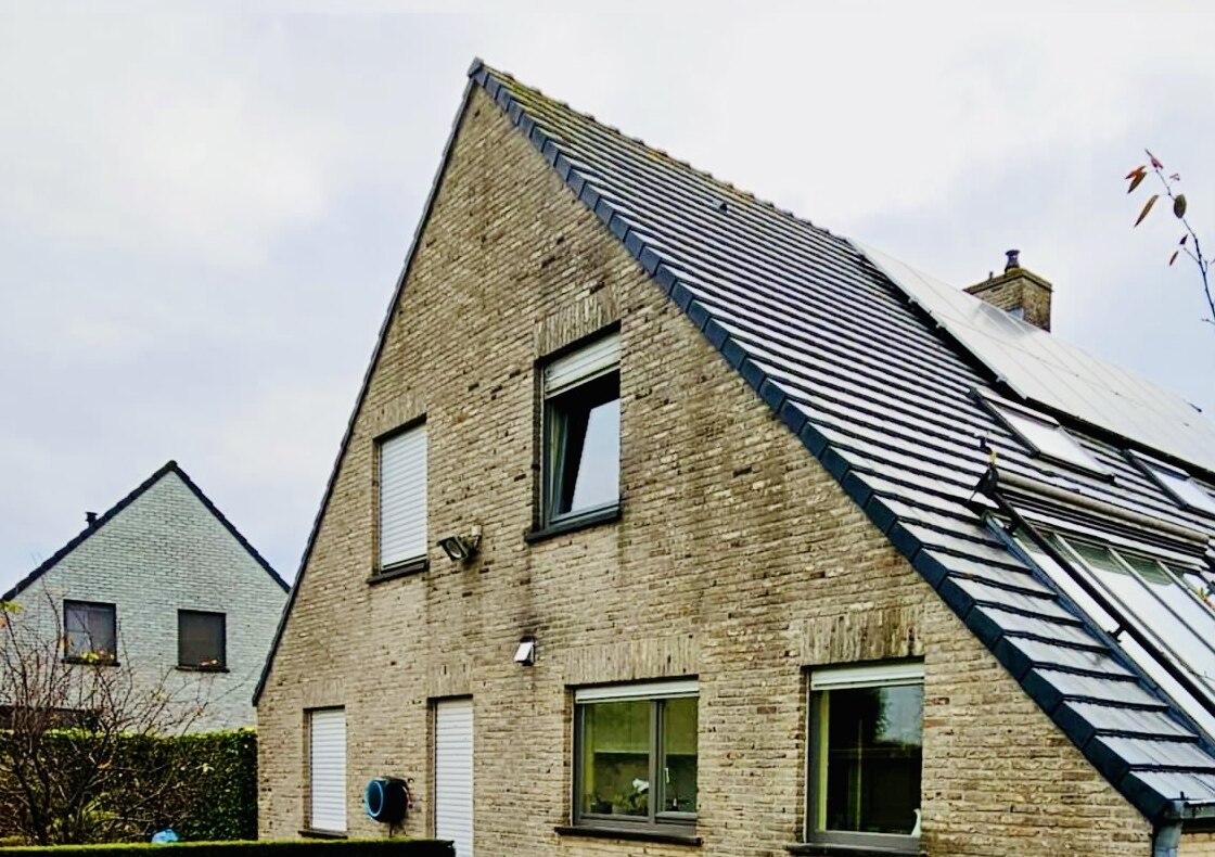 Woning met lichte bakstenen gevel en hellend dak met zonnepanelen